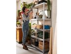 Woman organizing items on a five-shelf metal shelving unit.