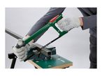 Person using a hacksaw to cut a metal square tube clamped in a workbench vise.