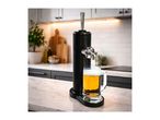 Black beer dispenser with a full mug of beer on a kitchen counter.