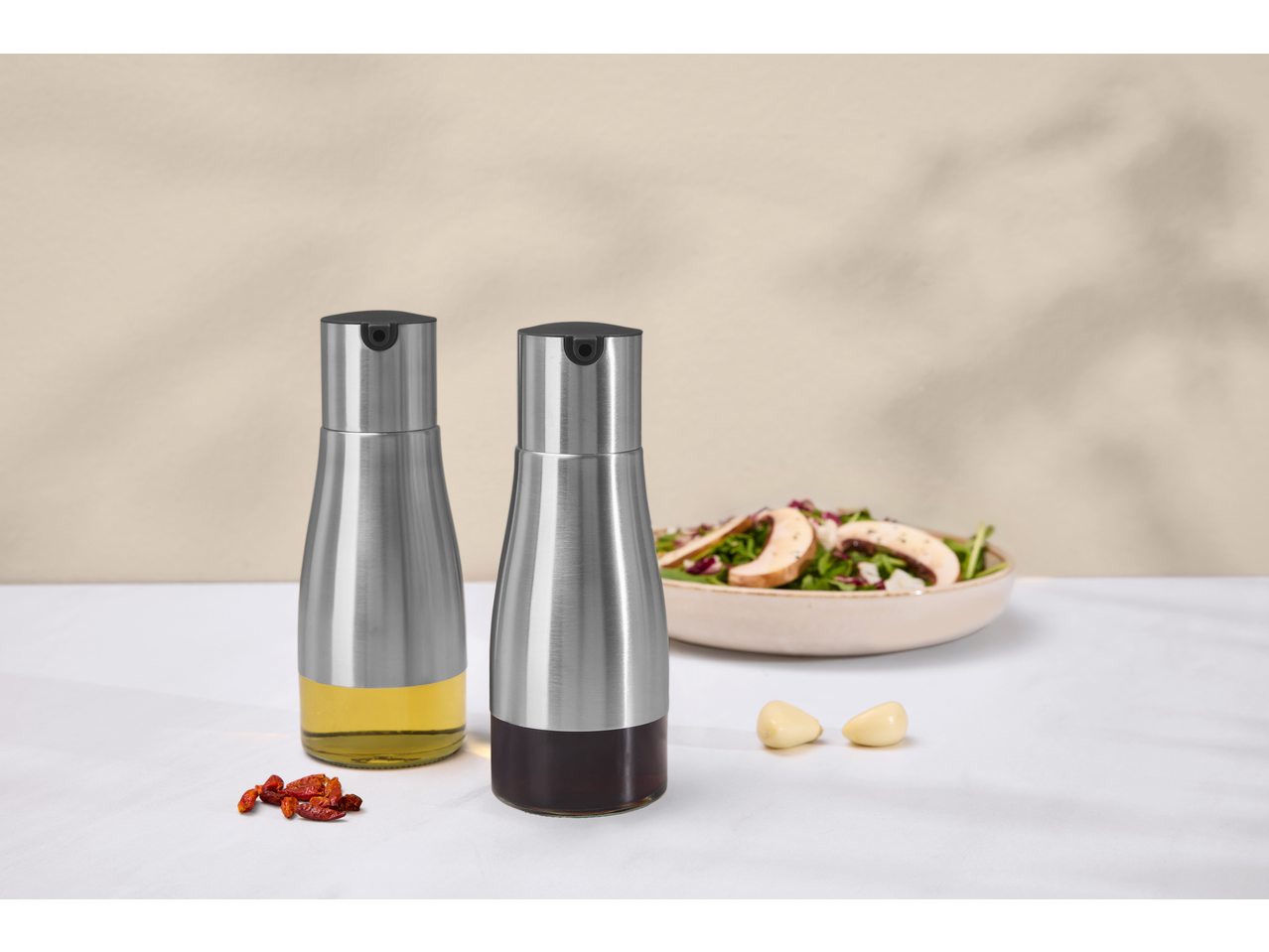 Două pulverizatoare de ulei și oțet din oțel inoxidabil, cu salată, usturoi și ardei iuți.