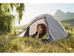 Woman relaxing inside a tent in a outdoor park.