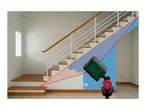 A green cross line laser level on a tripod projecting a red line along a staircase.