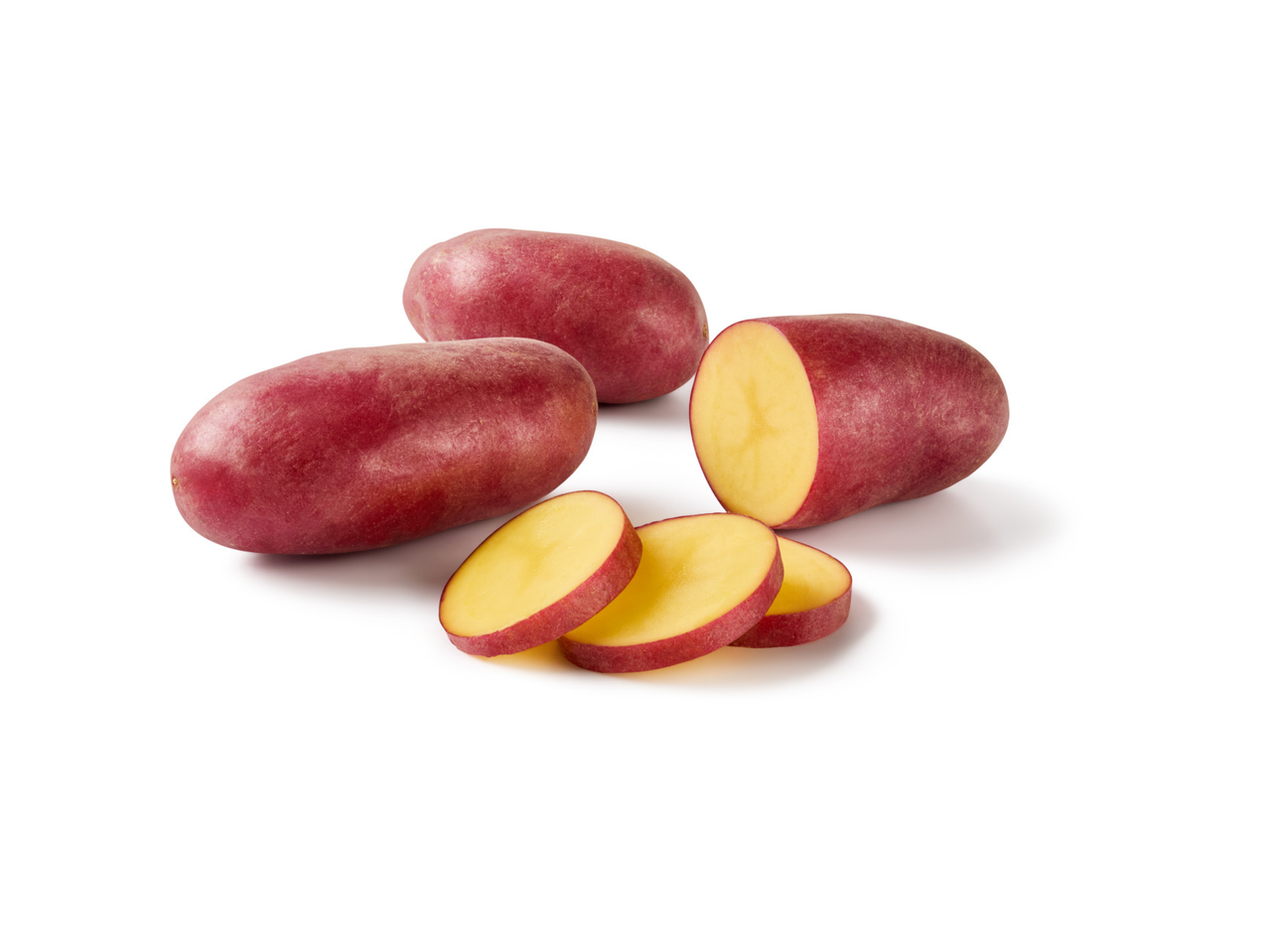 Crveni krumpir, cijeli i narezan na ploške, na bijeloj pozadini.