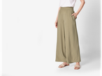 Pantaloni largi de culoare verde măsliniu cu sandale plate.