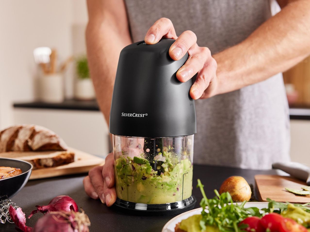 Egy férfi egy SilverCrest aprítógéppel guacamole-t készít.