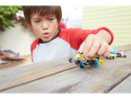 A child plays with Hot Wheels cars on a wooden table.