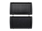 Open sandwich maker with two black, ridged cooking plates.