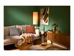 Living room with a beige sofa, floor lamp, wooden cabinet, and autumn decorations.
