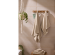 Bathroom with hanging plant, wooden towel rack with two beige towels, and a mint green radio.