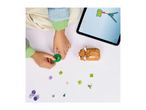 Child assembling a toy animal with building blocks, guided by instructions on a tablet.