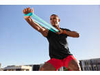 Man in CRIVIT sports shorts and t-shirt exercising with a resistance band.