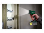Hand holding a cordless work light illuminating an electrical fuse box.