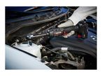 A cordless ratchet wrench being used to tighten a bolt under a car hood.