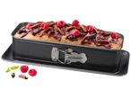 Loaf cake in a springform pan, topped with chocolate and raspberries