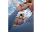 Women in CRIVIT sports bras and leggings doing yoga outdoors.