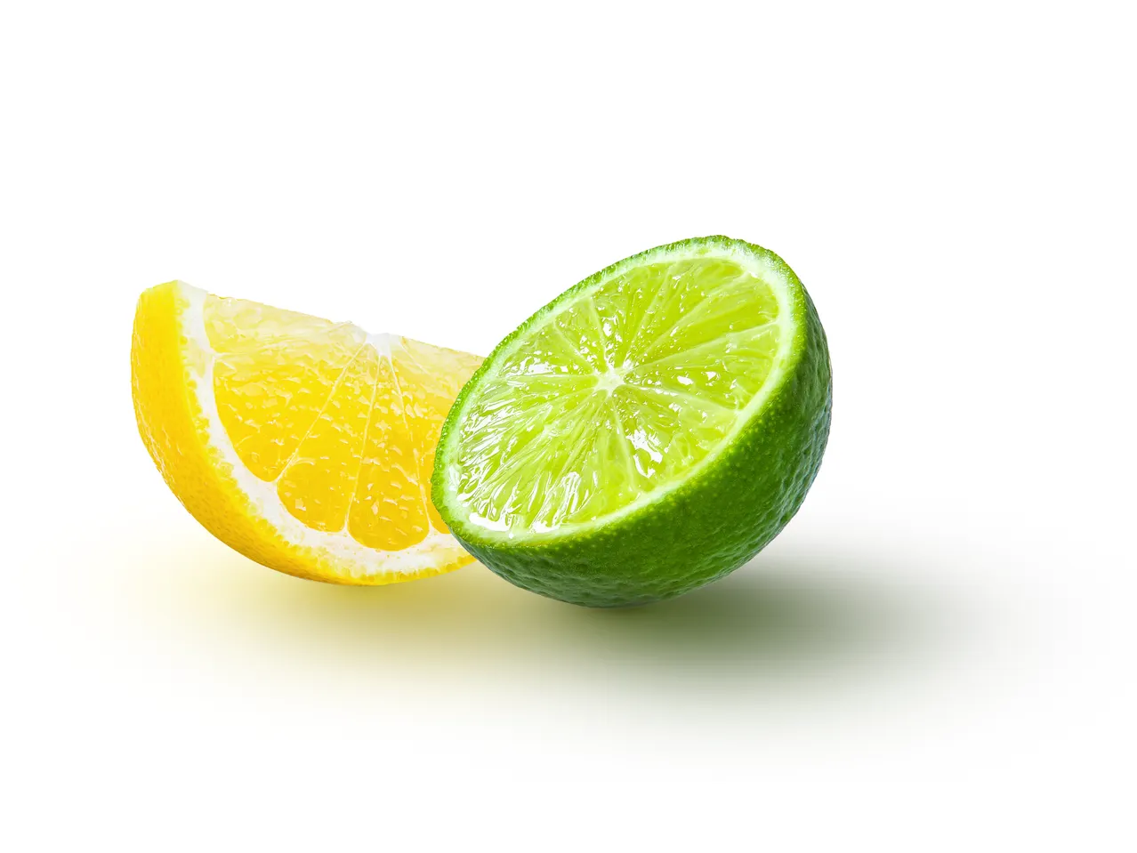 A lemon and lime wedge, juicy and vibrant, sit side-by-side against a white background.