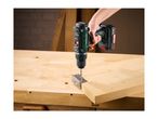 Cordless drill driving a screw into a metal hinge attached to a wooden plank on a workbench.