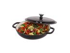 Black cast iron pot with a lid, filled with chopped vegetables.