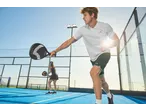 Duas pessoas jogam padel num campo azul, o homem segura uma raquete CRIVIT.
