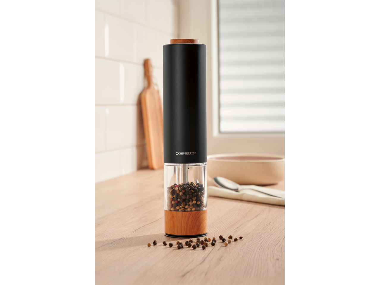 SILVERCREST® Electric Salt/Pepper Mill with mixed peppercorns on a kitchen counter.