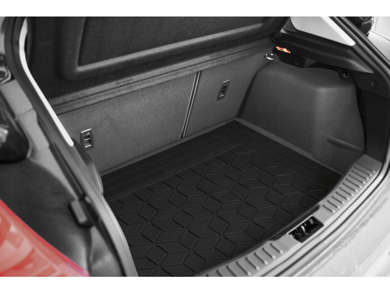 Car boot with a black rubber mat featuring a geometric pattern.