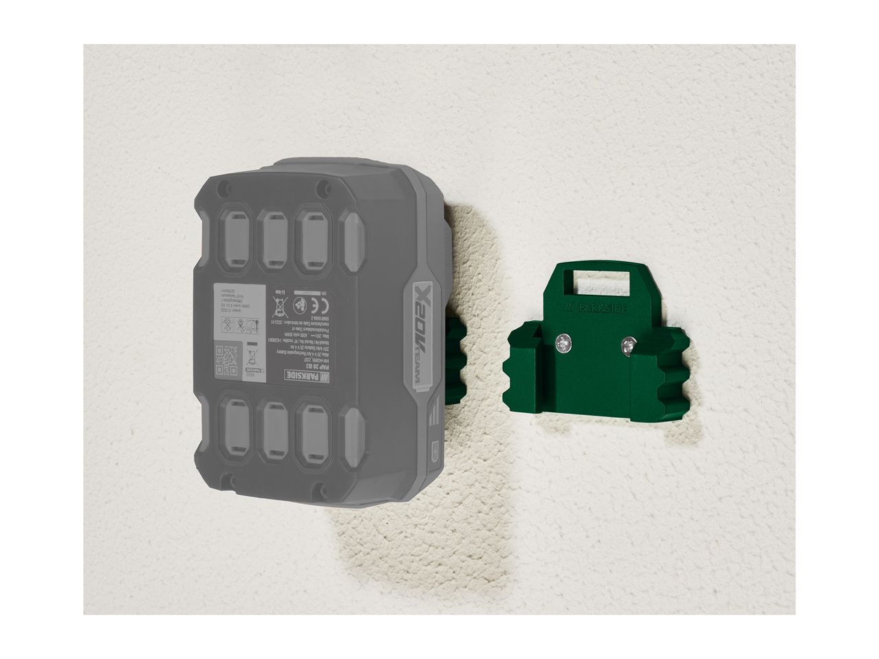 A gray Parkside battery pack mounted on a green wall holder.