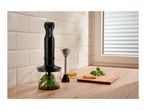 Black hand blender set with chopper attachment, beaker, and ingredients on a kitchen counter