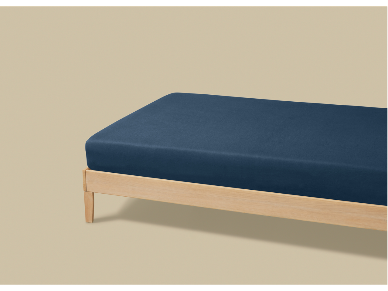 LIVARNO home tamnoplava jersey plahta na svijetlom drvenom krevetu