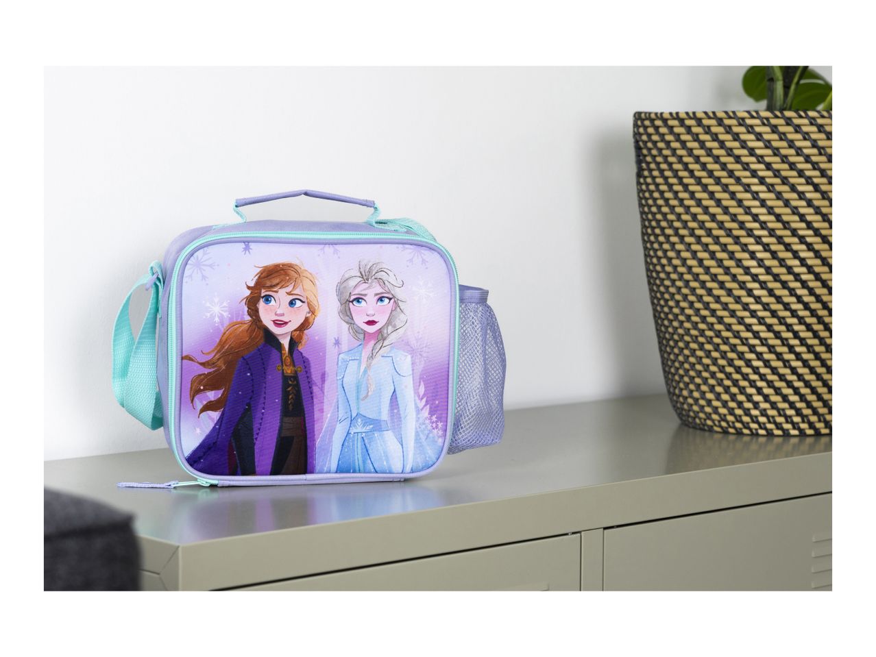 Frozen-themed lunch bag with Anna and Elsa, a side mesh pocket, and a turquoise strap.