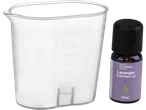 Prozirna mjerna posuda s ljubičastom bočicom ulja s mirisom lavande.