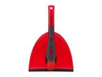 Red dustpan and brush set with black bristles, standing upright.