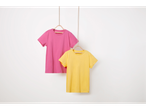 Δύο μονόχρωμα t-shirt, ένα ροζ και ένα κίτρινο, κρέμονται σε κρεμάστρες.