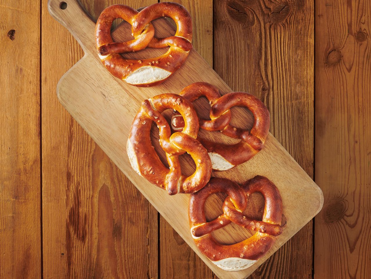 Солени претцели на дървена дъска.