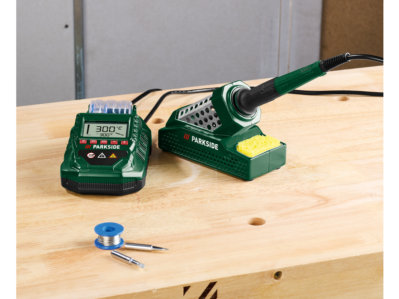 Stație de lipit PARKSIDE cu afișaj, letcon, suport și cositor pe o masă de lemn.