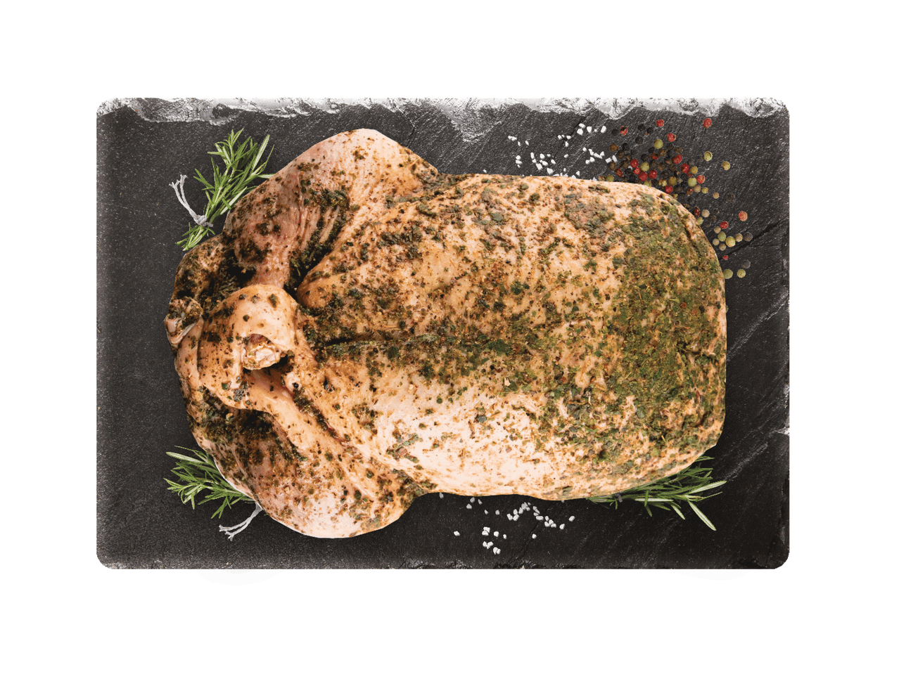 Jēla, ar garšvielām marinēta vista uz melna dēlīša ar rozmarīnu un garšvielām.