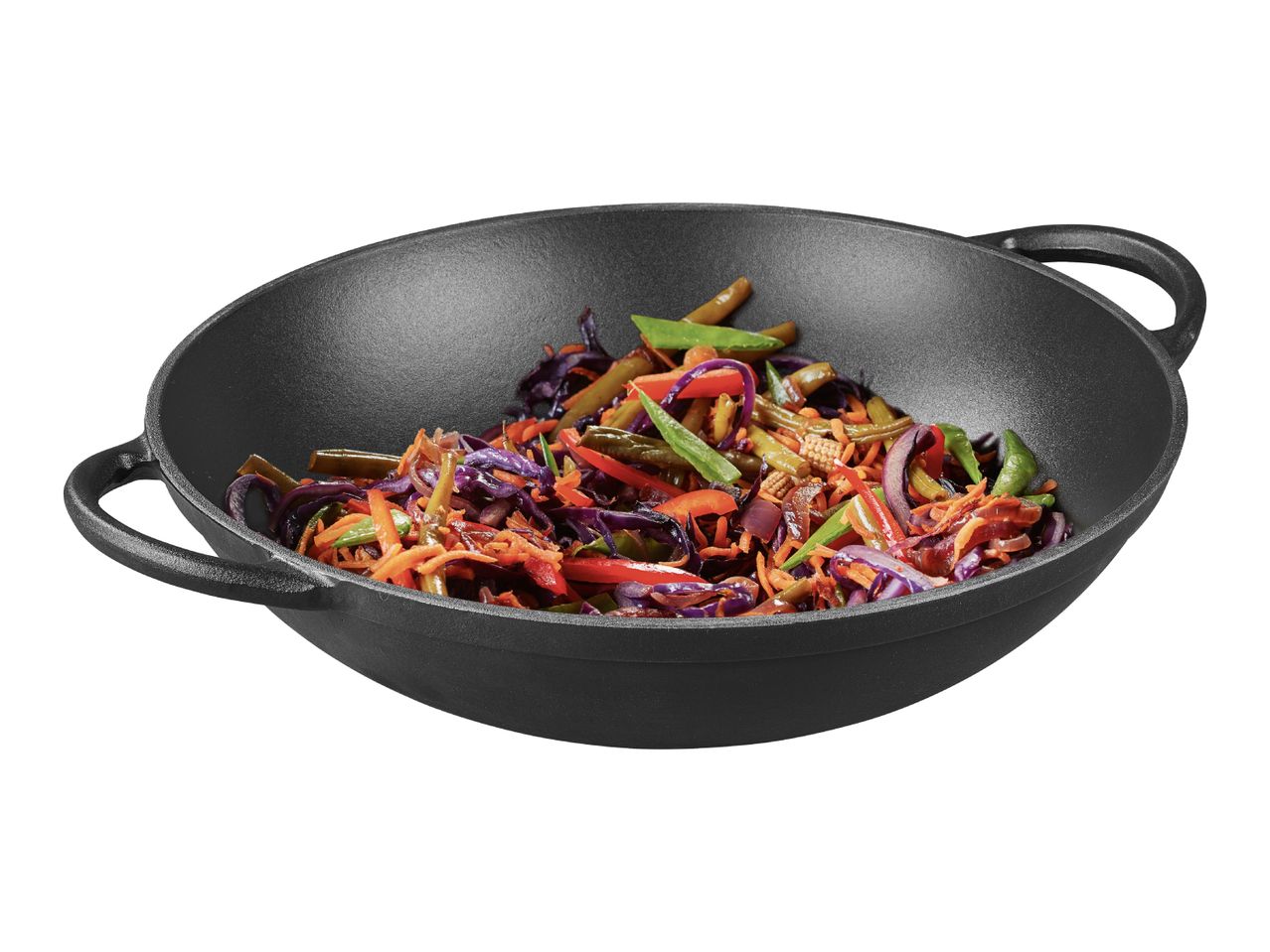 Cast iron wok with stir-fried vegetables including cabbage, carrots, and green beans.