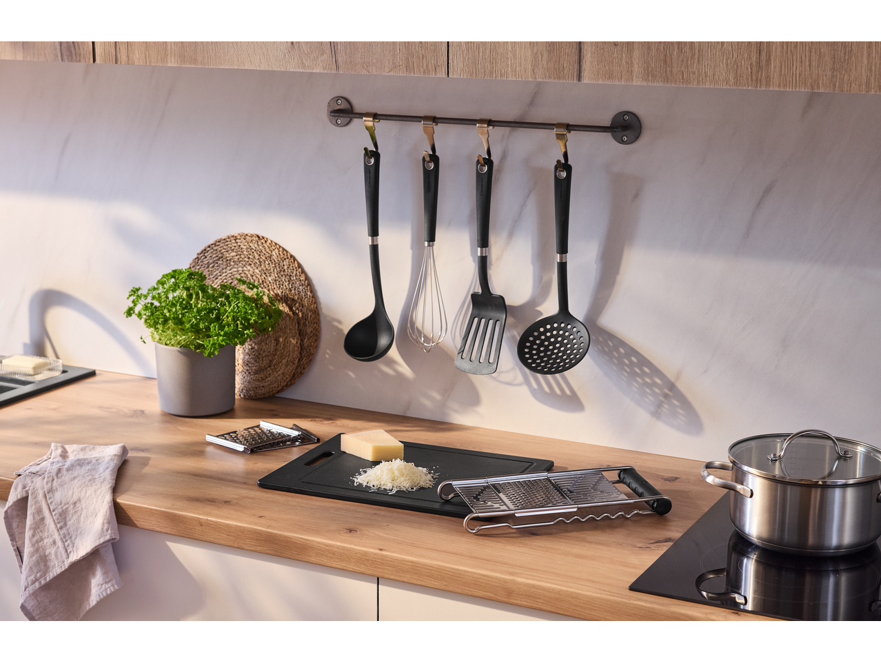 Tábua de corte SILVERCREST com queijo ralado, utensílios de cozinha e ervas frescas numa cozinha de madeira.