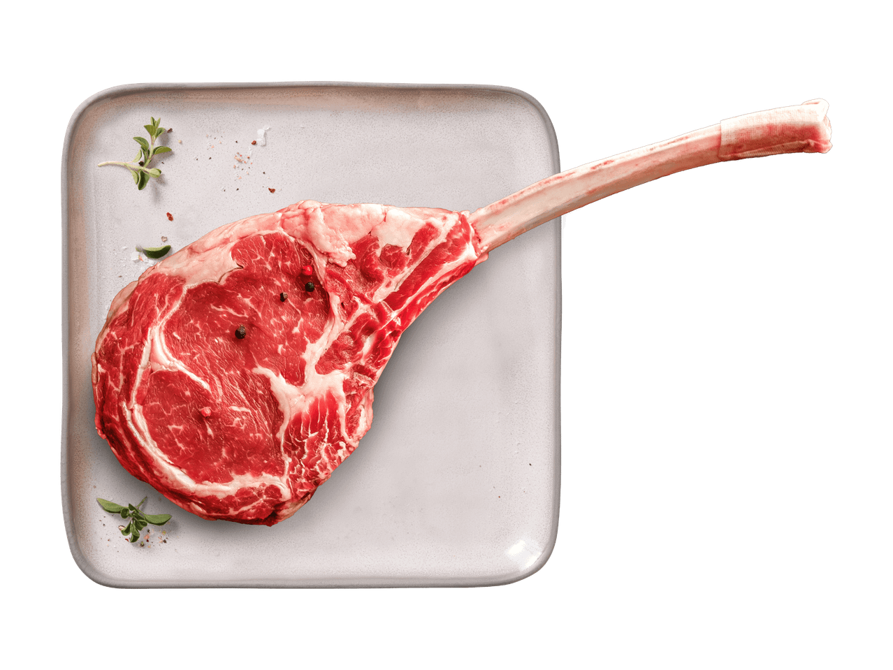 Rohes Tomahawk-Steak auf einer Platte mit Kräutern und Gewürzen.