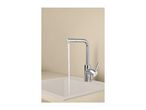 Chrome kitchen tap with running water over a light-colored sink.