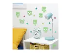 Minecraft-themed glow-in-the-dark wall decals adorn a child's bedroom, complementing a pastel-colored desk lamp and alarm clock.