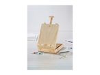 A wooden art easel with paints and brushes on a light wooden surface.