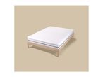 White mattress topper with elastic corner straps on a wooden bed frame