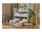 A child's room with a forest-themed wallpaper, a toy storage unit, and a storage ottoman.