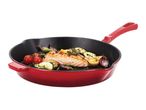Red cast iron skillet with cooked salmon, tomatoes, zucchini, and onions.