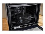 Black cast iron pot inside an open oven on a metal rack