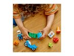 Child playing with building blocks, a police officer figure, and a toy motorcycle on a wooden table.