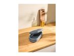Grey kitchen sink caddy with a removable strainer on a wooden countertop.
