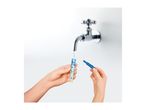 Hands filling a water testing tube from a tap, with a blue cap held nearby.