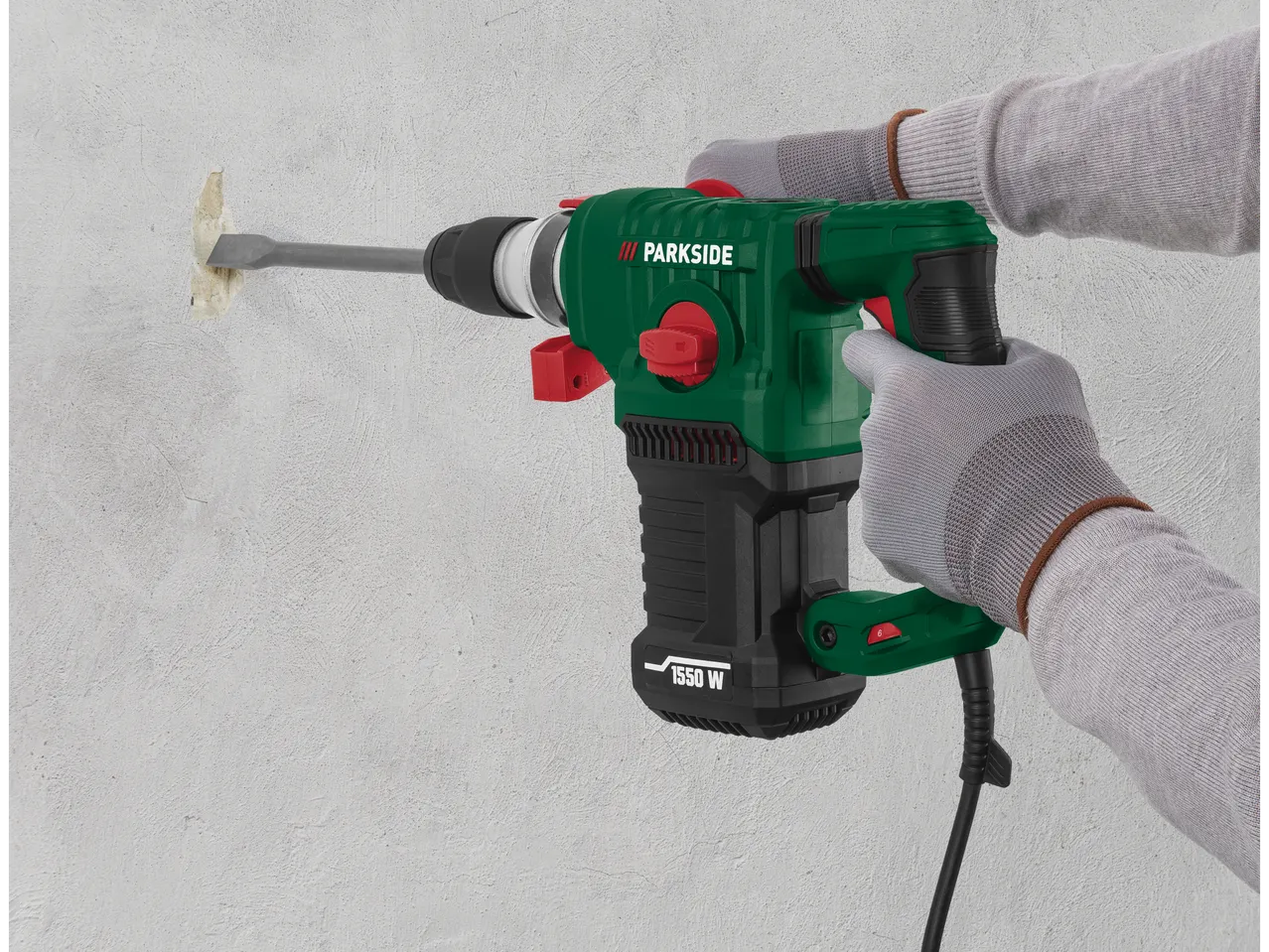 A worker uses a Parkside SDS-max demolition hammer to remove mortar from a wall.