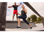 Woman in CRIVIT cropped sports leggings and man exercising outdoors.